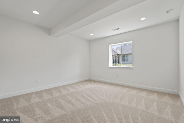 spare room with beamed ceiling and carpet floors