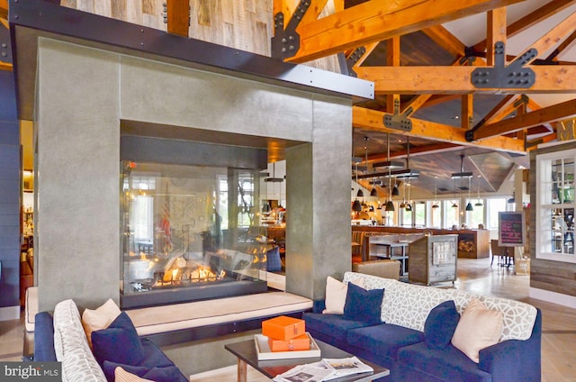 living room with high vaulted ceiling, beam ceiling, and a fireplace