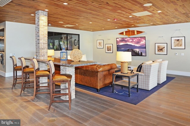 living room featuring wood ceiling, decorative columns, brick wall, and wood-type flooring