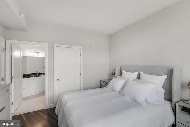 bedroom featuring dark hardwood / wood-style floors and ensuite bathroom