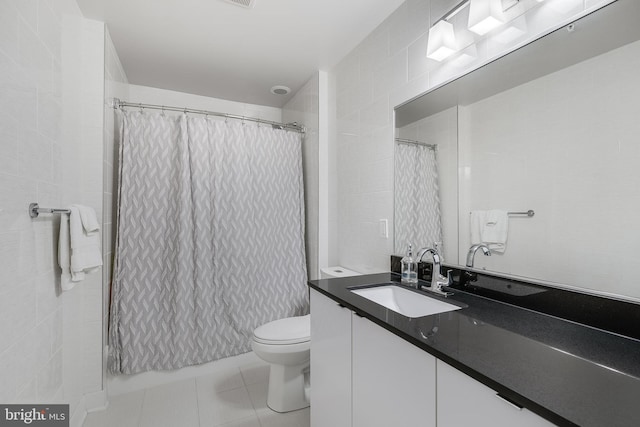 bathroom featuring tile patterned floors, vanity, toilet, and walk in shower