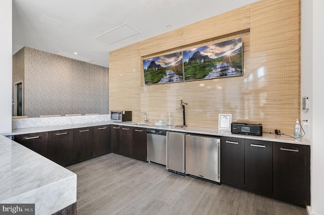 kitchen featuring dishwasher, sink, light wood-type flooring, fridge, and dark brown cabinetry