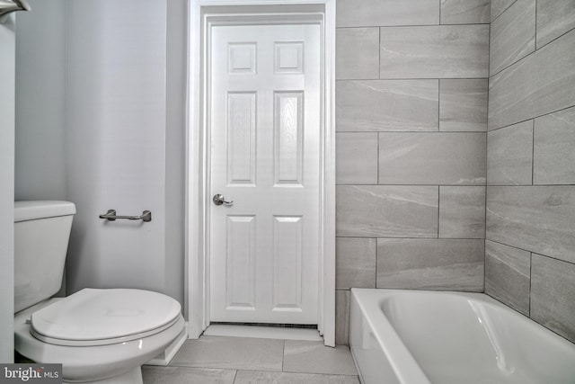 bathroom featuring toilet and a tub to relax in