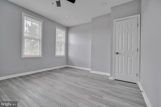 empty room with light hardwood / wood-style floors and ceiling fan