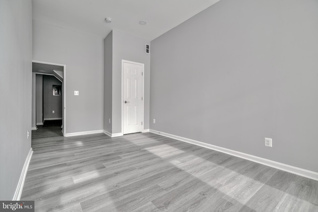 interior space featuring light hardwood / wood-style flooring and a towering ceiling