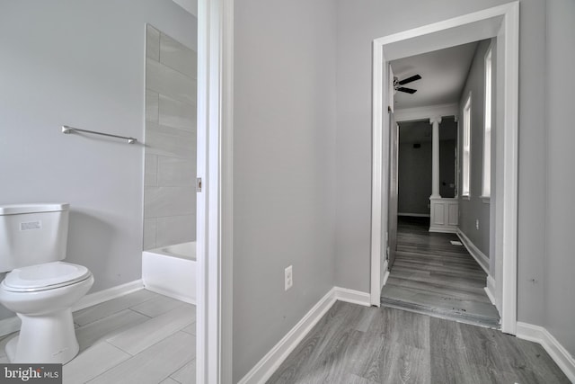 bathroom with ceiling fan, hardwood / wood-style floors, and toilet