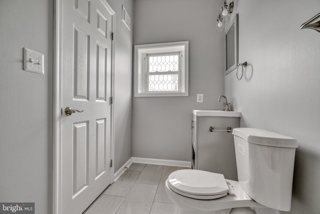 bathroom featuring tile patterned flooring, vanity, and toilet