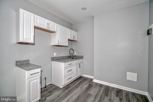 kitchen with sink, white cabinets, and dark wood-type flooring