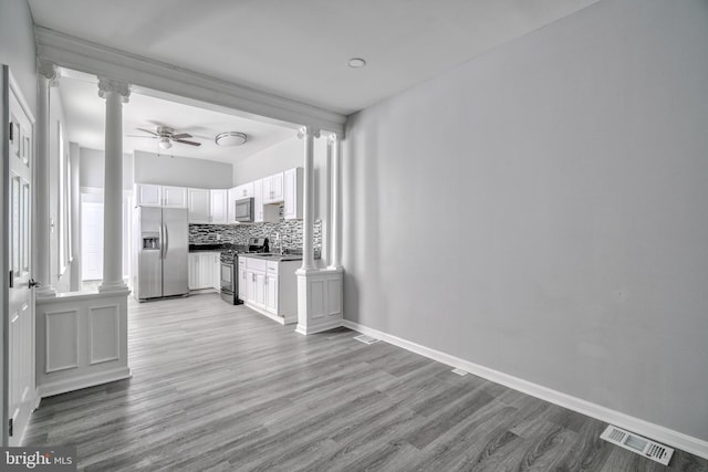 kitchen with decorative backsplash, appliances with stainless steel finishes, ceiling fan, light hardwood / wood-style flooring, and white cabinetry