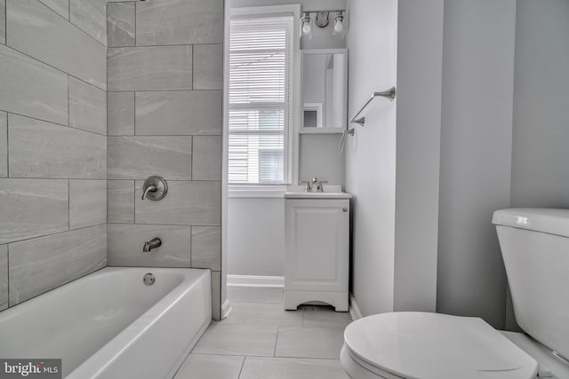 full bathroom with tile patterned floors, vanity, tiled shower / bath combo, and toilet