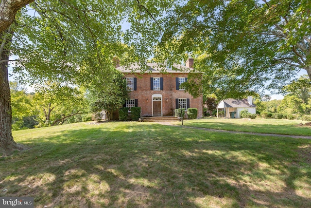 1791 Warrenton Rd, Fredericksburg, VA 22406 - georgian-style home with brick siding, a front lawn, a chimney, and an outdoor structure