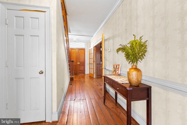 unfurnished living room featuring ornamental molding, dark wood-type flooring, a notable chandelier, and a brick fireplace