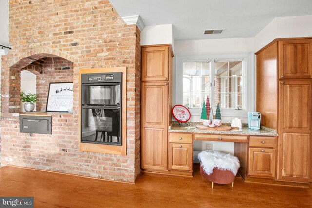 kitchen with hardwood / wood-style floors, a healthy amount of sunlight, and decorative light fixtures