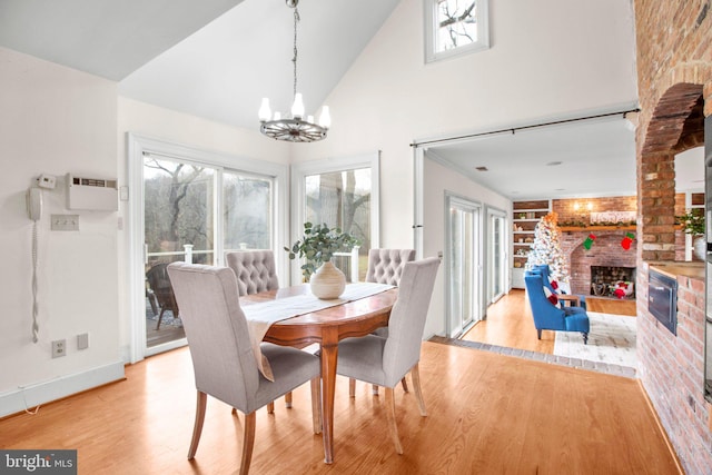1791 Warrenton Rd, Fredericksburg, VA 22406 - dining space with a fireplace, light wood finished floors, a chandelier, plenty of natural light, and high vaulted ceiling