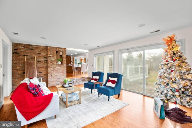 unfurnished living room with hardwood / wood-style floors, built in shelves, crown molding, and a brick fireplace