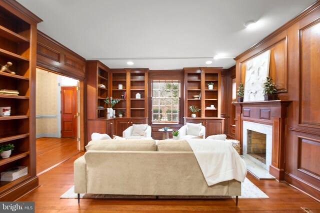 unfurnished living room featuring crown molding, a fireplace, and wood-type flooring