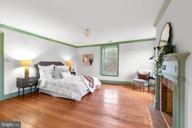 1791 Warrenton Rd, Fredericksburg, VA 22406 - bedroom featuring crown molding, hardwood / wood-style floors, and a brick fireplace