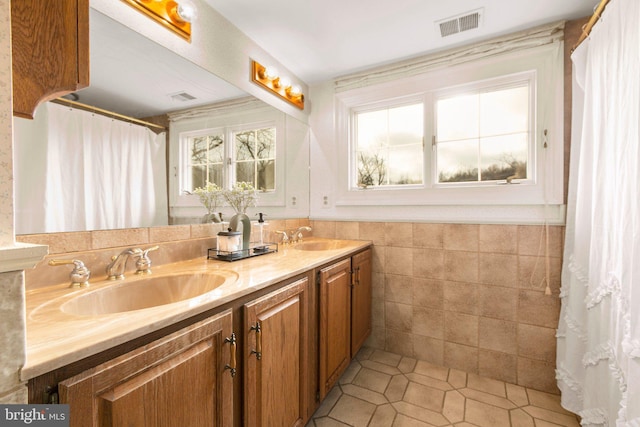 1791 Warrenton Rd, Fredericksburg, VA 22406 - bathroom featuring tile patterned floors, tile walls, double vanity, and a wainscoted wall