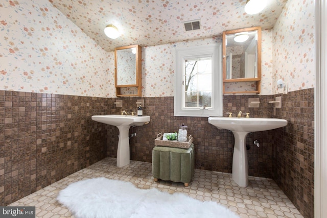 1791 Warrenton Rd, Fredericksburg, VA 22406 - bathroom featuring tile walls, wainscoting, vaulted ceiling, tile patterned flooring, and wallpapered walls