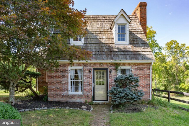 rear view of house featuring a wooden deck and a yard