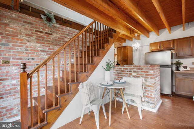 kitchen with beam ceiling, sink, dark wood-type flooring, stainless steel fridge, and decorative light fixtures