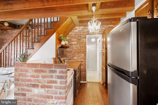 1791 Warrenton Rd, Fredericksburg, VA 22406 - kitchen featuring freestanding refrigerator, brick wall, light wood-style flooring, beam ceiling, and a chandelier