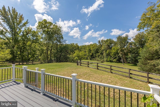 wooden deck with a yard and a rural view