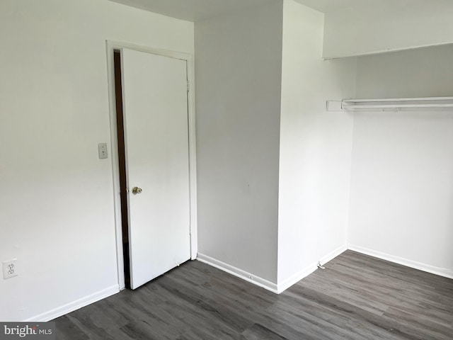 unfurnished bedroom featuring dark wood-style floors and baseboards