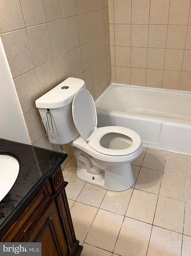 bathroom with toilet, vanity, and tile patterned floors