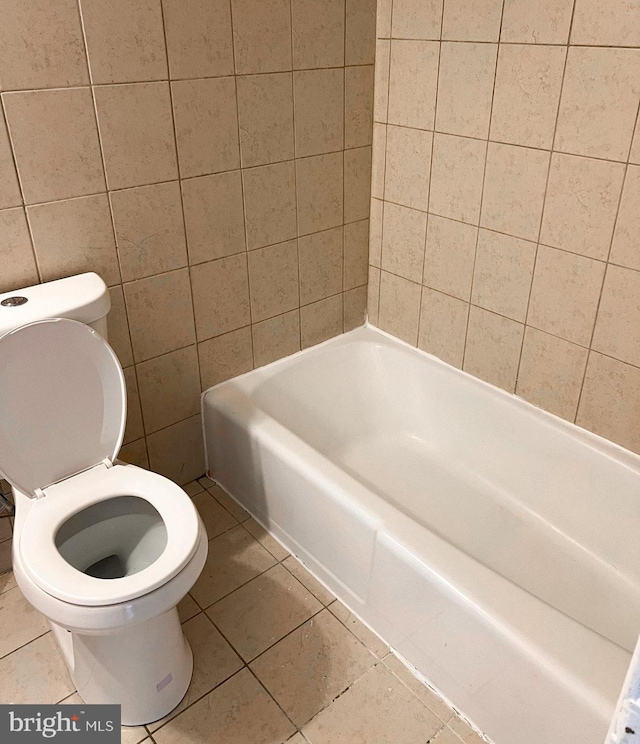 bathroom featuring tile patterned flooring, toilet, and a bathing tub