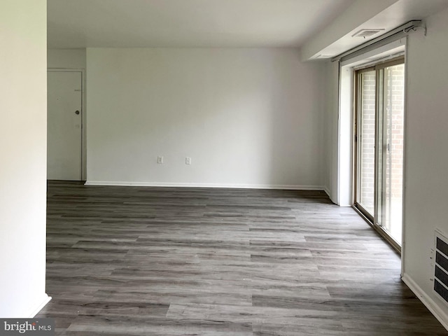 unfurnished room with plenty of natural light, baseboards, and wood finished floors