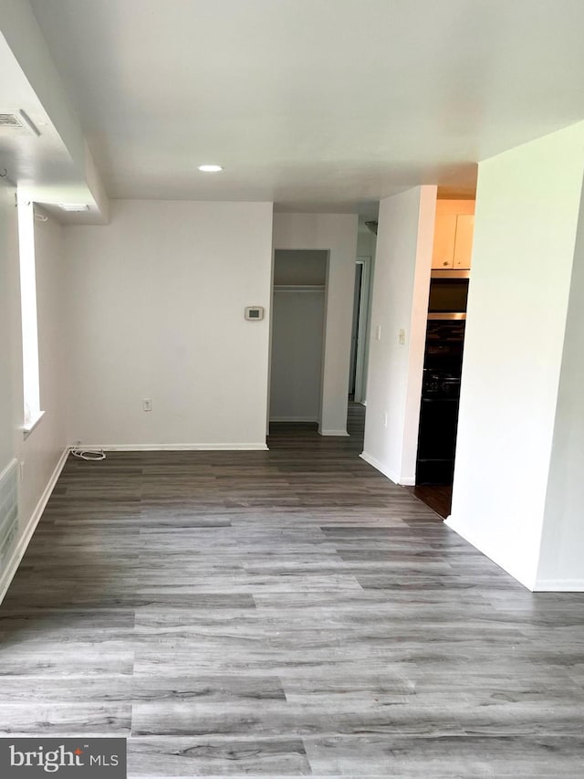 unfurnished room with visible vents, baseboards, and wood finished floors