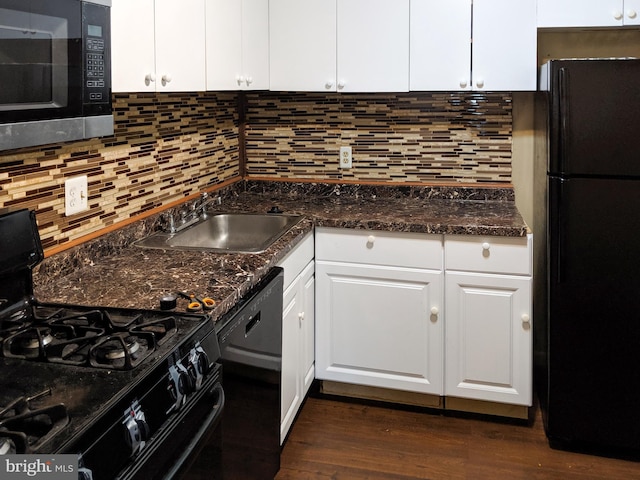 kitchen with decorative backsplash, white cabinets, a sink, dark stone counters, and black appliances