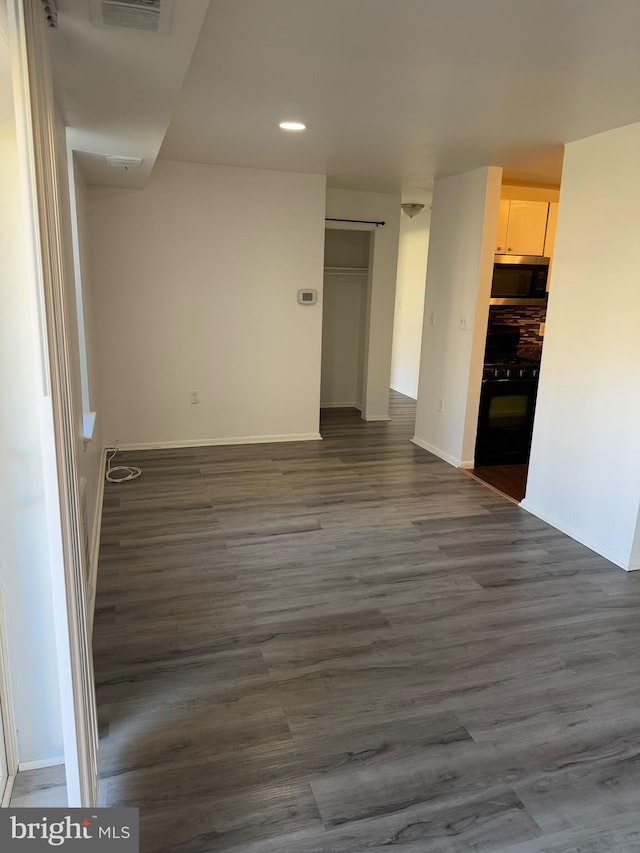 unfurnished room featuring recessed lighting, dark wood finished floors, visible vents, and baseboards