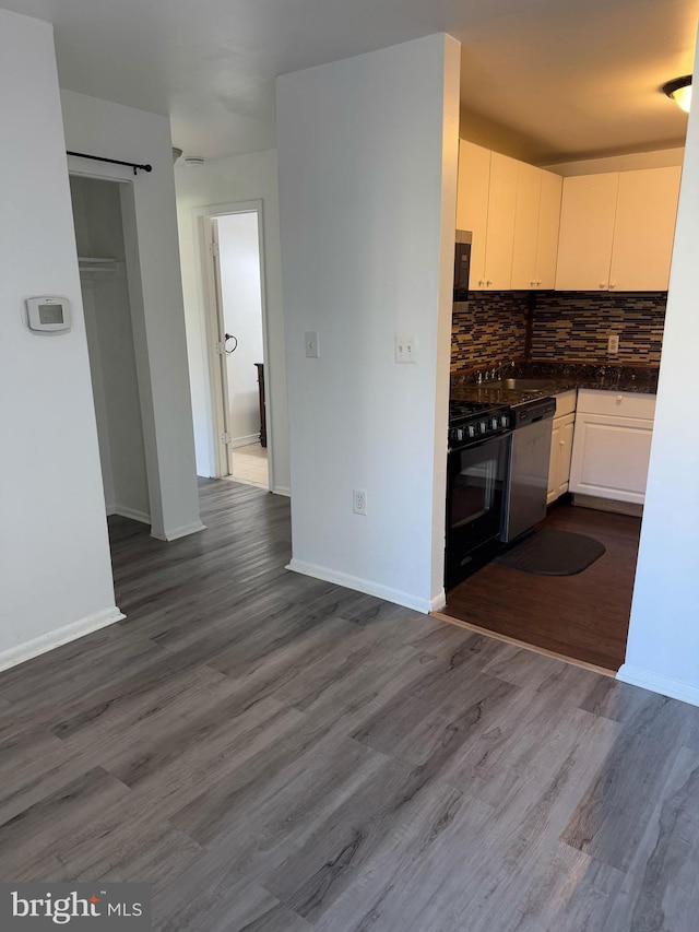 kitchen featuring tasteful backsplash, dark countertops, a barn door, appliances with stainless steel finishes, and white cabinets