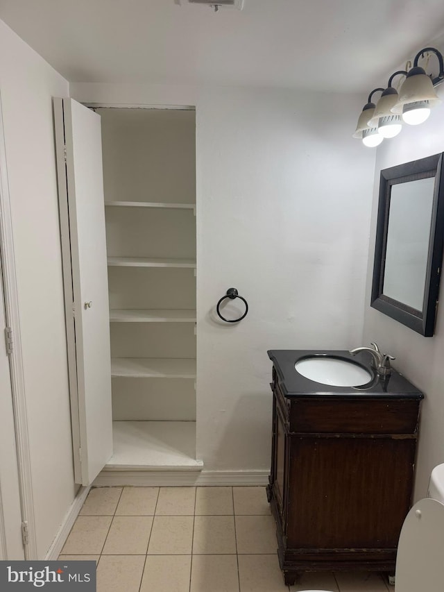 bathroom featuring tile patterned flooring, a closet, vanity, and baseboards