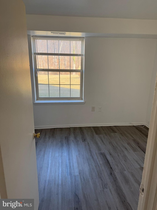 unfurnished room featuring dark wood-style floors and baseboards