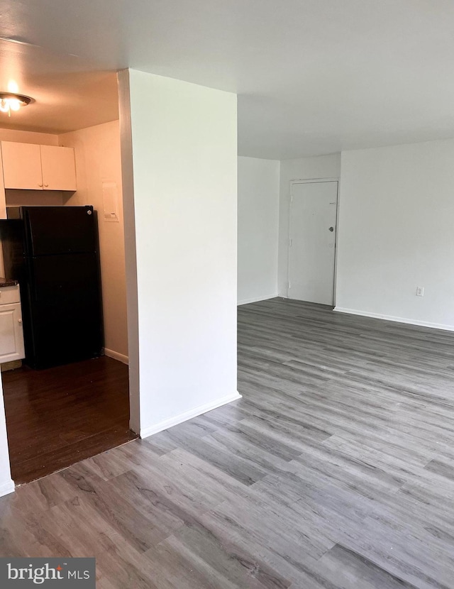 unfurnished room featuring baseboards and wood finished floors