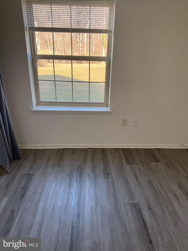 empty room featuring baseboards and wood finished floors