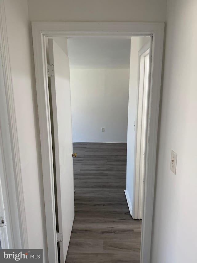 hallway with dark wood finished floors and baseboards