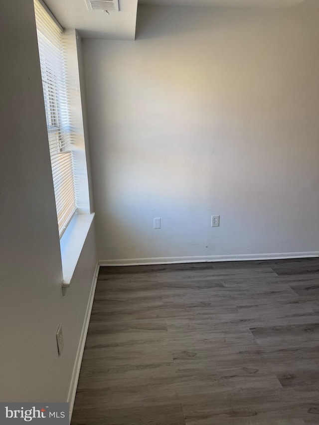 unfurnished room featuring dark wood-style floors and baseboards