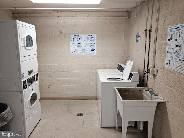 community laundry room with separate washer and dryer, stacked washer / dryer, and concrete block wall