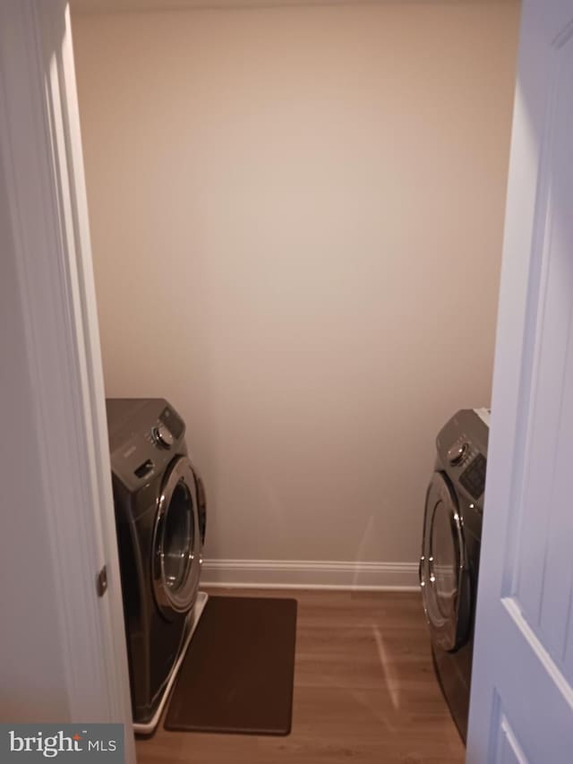 washroom with wood-type flooring and separate washer and dryer