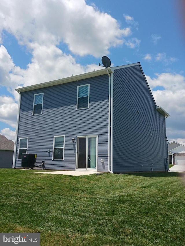 back of house featuring a lawn, a patio area, and central air condition unit