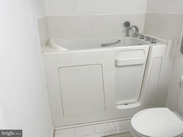 bathroom featuring a bathtub, toilet, and tile patterned floors