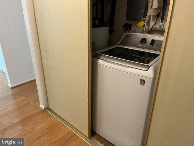 washroom featuring washer / clothes dryer, water heater, light wood-type flooring, and electric panel