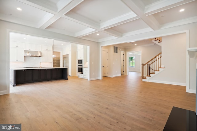 unfurnished living room with coffered ceiling, light wood-type flooring, and beam ceiling