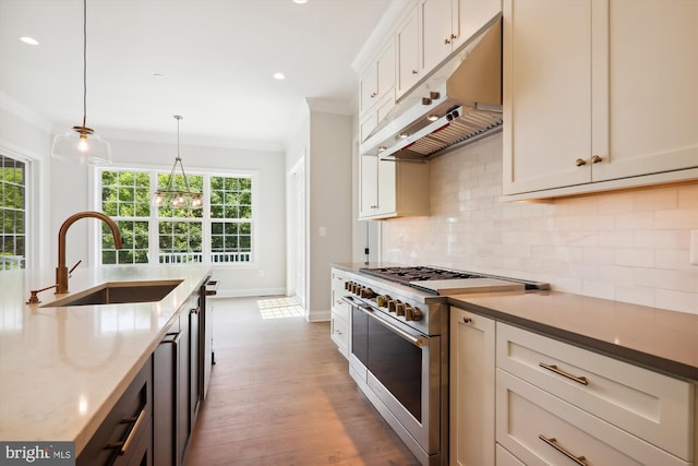 kitchen featuring dark stone countertops, pendant lighting, double oven range, sink, and backsplash