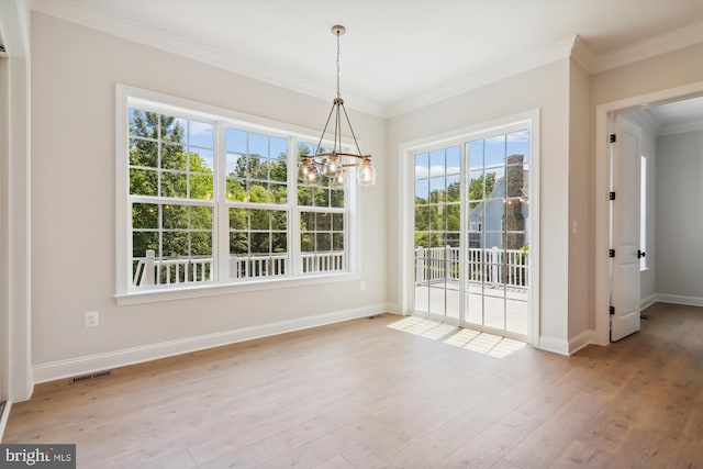 unfurnished dining area with ornamental molding, a chandelier, and light wood-type flooring