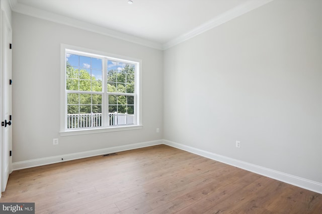 unfurnished room with ornamental molding and light wood-type flooring